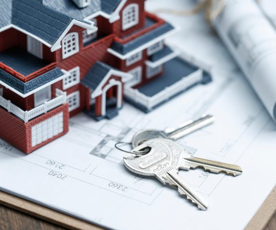 villa house model, key and drawing on retro desktop (real estate sale concept)